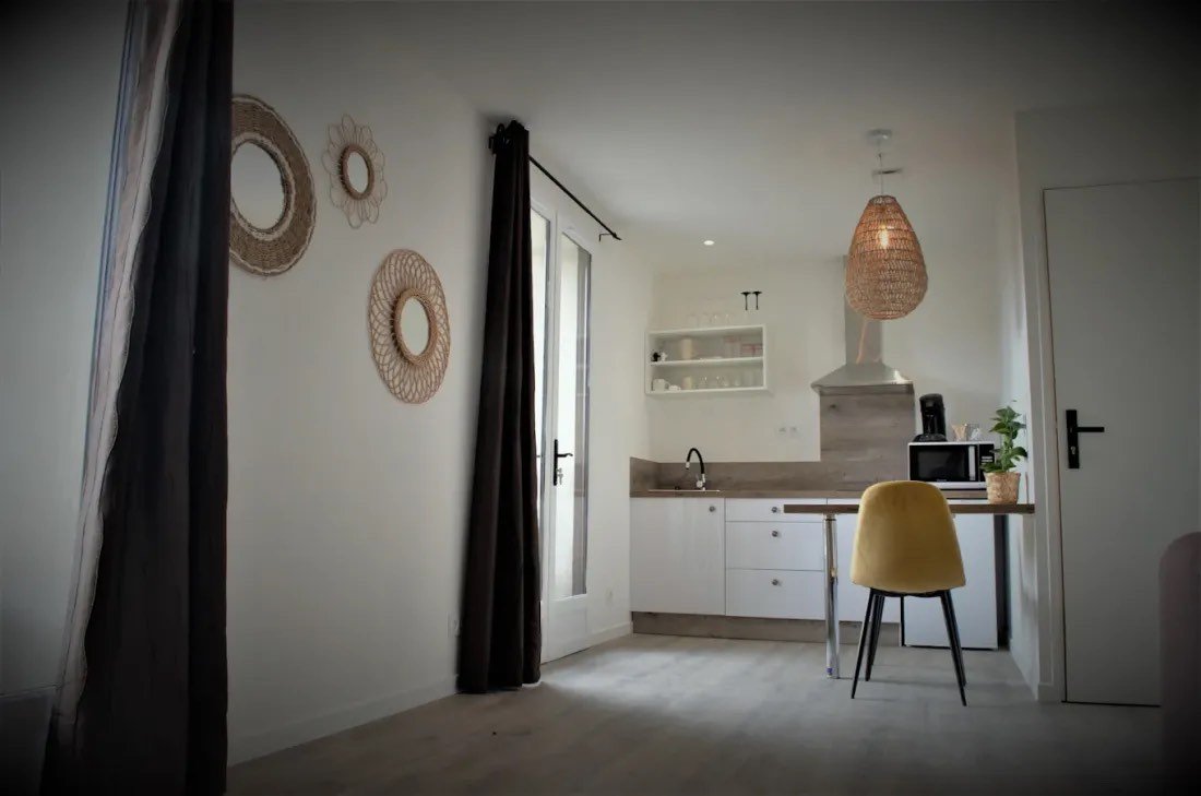 Studio rafraîchi : murs repeints, kitchenette blanche et sol stratifié